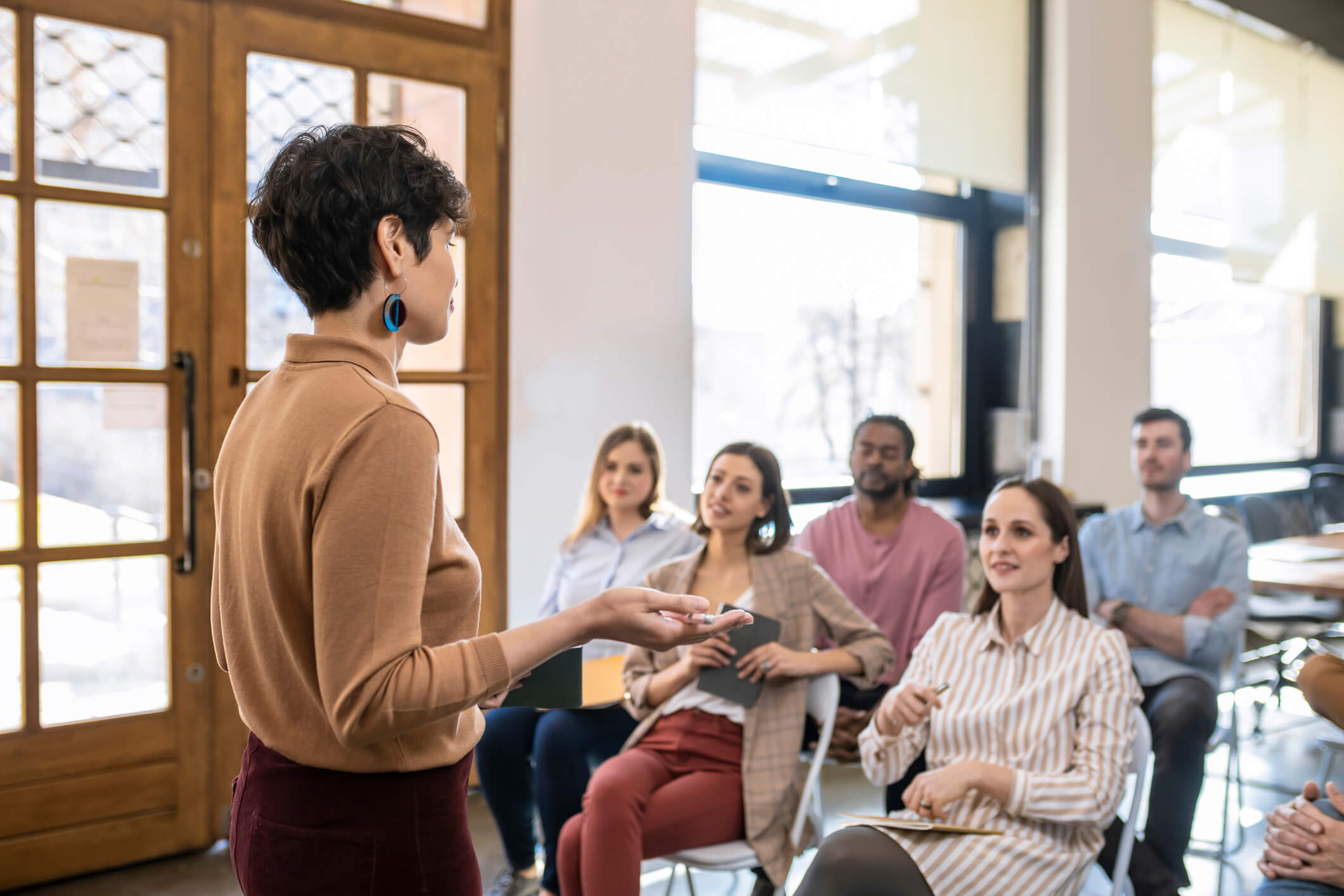 Woman giving a talk to a room of colleagues.
